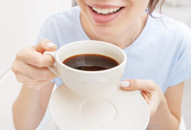Femme buvant du café, facteur de jaunissement dentaire